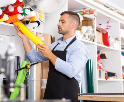 Warehouse worker reaching for stock on a high shelf