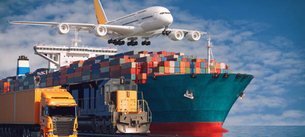 Cargo plane flying over a container ship being loaded at port, with a freight truck in the foreground